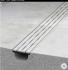 a concrete bench sitting on top of a cement floor next to a sidewalk with metal bars