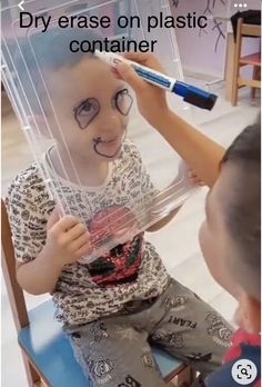 a little boy sitting in a chair with a plastic container on his head and the caption says, dry erase on plastic container