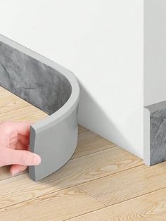 a person's hand is touching the corner of a wall