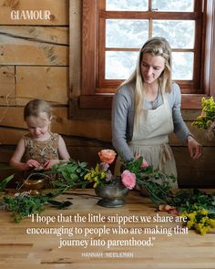 a woman and child are standing in front of a table that has flowers on it