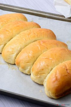 bread rolls lined up on a baking sheet