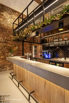 a bar with brick walls and plants on the top shelf, along with metal railings