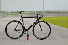 a black bike parked on the side of a road