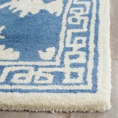 a blue and white rug with an animal design on the bottom, sitting on a wooden floor