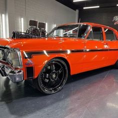 an orange classic car parked in a garage