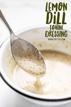 a spoon full of soup in a white bowl with the words lemon dill tahini dressing