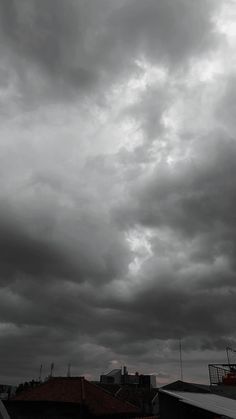 black and white photograph of storm clouds over rooftops