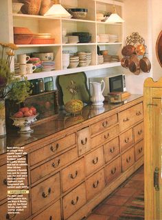 an old fashioned kitchen with wooden cabinets and drawers