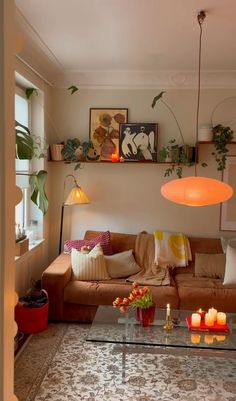 a living room filled with furniture and lots of plants on top of the wall next to a window