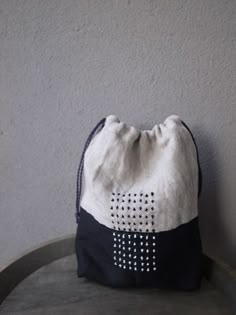 a white and black bag sitting on top of a table next to a gray wall