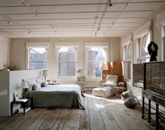 a bedroom with wooden floors and white walls