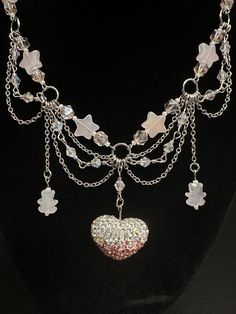 This is a magical, pink, shiny fairycore necklace! It has glass beads, a large, crystalized heart pendant, and is paired with matching earrings ✨ The necklace is 15" long, and the earrings are about 2.5" from where they attach to the fishhook hardware. Need an extension on the necklace? Send me a message and we can talk about options! ⛓️💥 Jewellery Pictures Ideas, Earrings And Necklace Sets, Whimsical Silver Jewelry With Heart Beads, Handmade Silver Fairy Kei Jewelry, Handmade Fairy Kei Silver Jewelry, Pink Crystal Dangle Necklaces, Fairycore Heart-shaped Jewelry Gift, Handmade Fairy Kei Jewelry For Party, Fairycore Heart-shaped Gift Jewelry