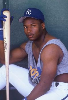 a baseball player poses with his bat