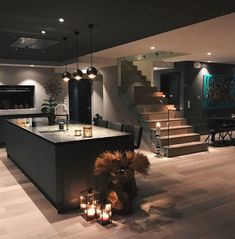 an image of a living room with candles on the floor and stairs in the background