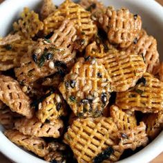 a white bowl filled with cheesy crackers and raisins