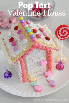 a paper plate with a house made out of candy and marshmallows on it