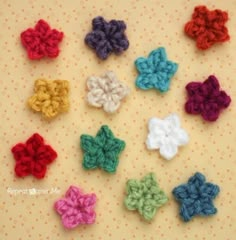 small crocheted flowers are arranged on a polka dot surface, with dots in the background