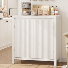 a kitchen with white cabinets and counter top next to a coffee maker on the wall