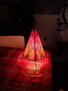 a triangle shaped lamp sitting on top of a table