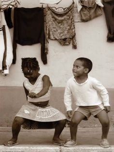 two children are sitting on a bench outside