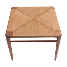 a small wooden table with a woven seat on the top and bottom, against a white background