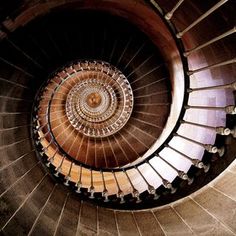 a spiral staircase with wooden steps leading up to the top