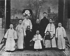 an old black and white photo of people in traditional chinese garb with flowers on their heads