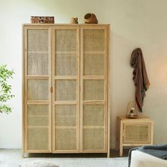 a room with a wicker cabinet and rugs on the floor next to it