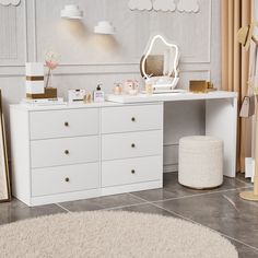 a white desk with drawers and a mirror on the top, next to a rug