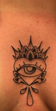 a chest tattoo with an all seeing eye in the center and a crown on top