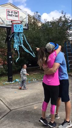 two people hugging each other in front of a basketball hoop with an octopus on it