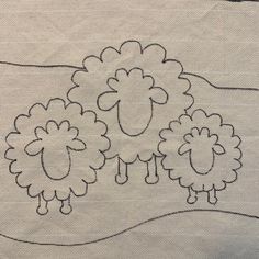 two sheep are standing in the middle of a line on a piece of cloth that has been stitched together