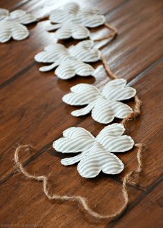 some white flowers are on the floor and string is strung up with twine to make it look like they have been made out of yarn