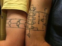 two people with matching tattoos on their arms, one has a circuit board tattoo on his arm