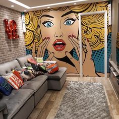 a living room filled with furniture and a large mural on the wall behind the couch