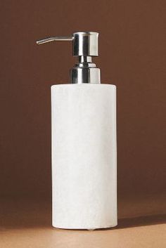 a white soap dispenser sitting on top of a table