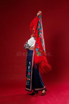 Portrait of ukrainian woman in traditional ethnic clothing and floral red wreath on viva magenta studio background twirls a royalty free stock photo Red Wreath, Viva Magenta, Studio Background, Wreath