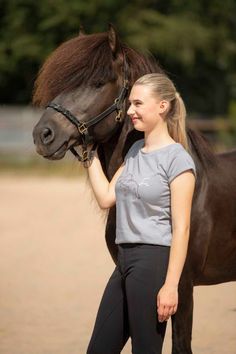 a woman is petting a horse on the nose