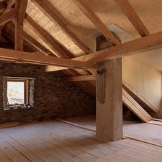 an empty room with wooden flooring and exposed beams on the ceiling, two windows are open