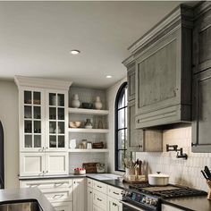 a kitchen with white cabinets and black counter tops