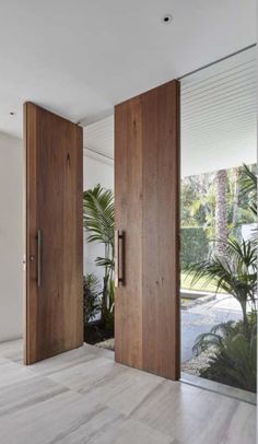 two wooden doors are open on the inside of a room with white walls and wood floors