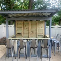 an outdoor bar with stools and tables