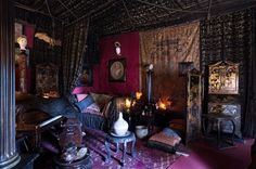 a living room filled with lots of furniture and decor on top of a purple rug