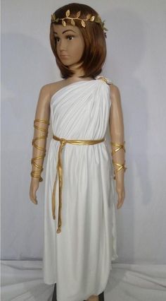 a mannequin wearing a white dress with gold trims on it's head