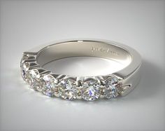 a white gold wedding band with five round brilliant cut diamonds on the side, set in 18k white gold