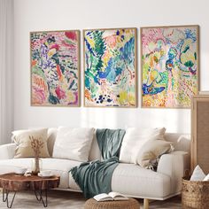 a living room with three paintings on the wall