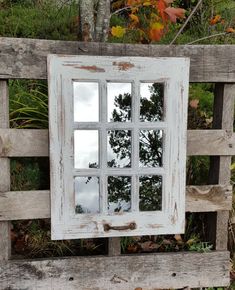 an old window is sitting on a wooden bench