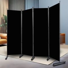 a room divider with three black screens in front of a couch and coffee table