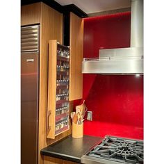 a kitchen with red painted walls and stainless steel appliances in the cabinetry, along with an oven