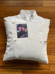 a white pillow with an image of two people in the middle and one is wearing a jacket